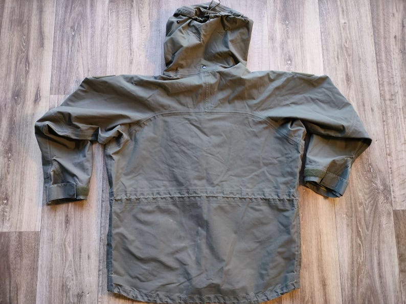 May include: A green hooded jacket with a drawstring hood and adjustable cuffs. The jacket has a zipper closure and a drawstring waist. The jacket is made of a lightweight material and is suitable for outdoor activities.