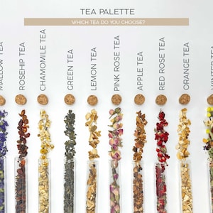 May include: A tea palette with 10 different types of tea, including mallow, rosehip, chamomile, green, lemon, pink rose, apple, red rose, orange, and winter tea. Each tea is displayed in a glass test tube with a cork stopper.