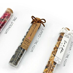 May include: Three glass test tubes filled with dried tea leaves and flower petals. The test tubes are tied with twine and a tag. The tags are labeled "Without Tag", "With Tag - Craft", and "With Tag - White".