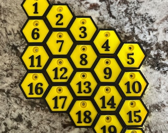 May include: A set of 20 yellow hexagonal numbered tags with black outlines and numbers. The tags are arranged in a honeycomb pattern.