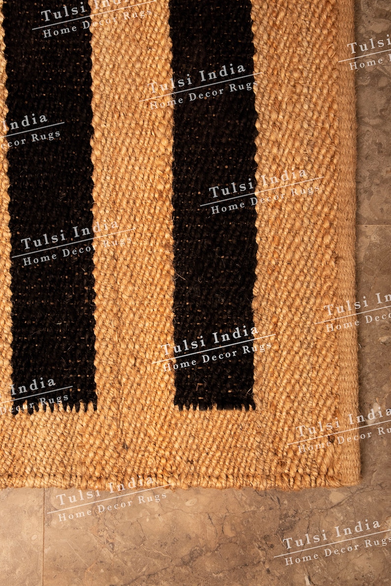 May include: A natural fibre rug with black stripes. The rug is made of jute and has a woven texture. The rug is labelled "Tulsi India Home Decor Rugs".