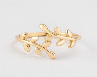 May include: A gold ring with a delicate design of two intertwined branches with leaves.