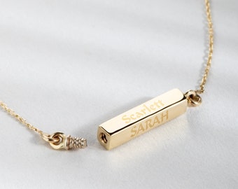May include: Gold bar necklace with the names "Scarlett" and "Sarah" engraved on it.