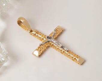 May include: A gold cross pendant featuring an intricate, openwork filigree pattern throughout the arms. A silver-toned figure of Jesus is centered on the front of the cross. The pendant includes a smooth, polished gold bail at the top for hanging.