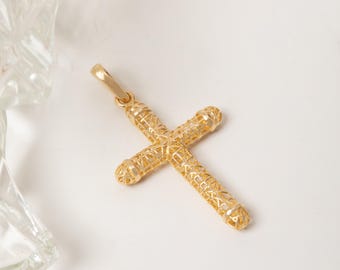 May include: A gold cross pendant featuring a hollow, cylindrical design with a delicate, open-work lattice pattern throughout the structure. The pendant includes a small, integrated bail at the top for attachment to a chain or necklace.
