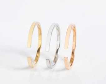 May include: Three simple open rings in gold, silver, and rose gold.