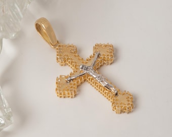 May include: A gold cross pendant featuring a textured, openwork lattice design on the arms and a polished silver-toned figure of Jesus centered on the front. The pendant includes a smooth, tapered gold bail at the top for attachment to a chain.
