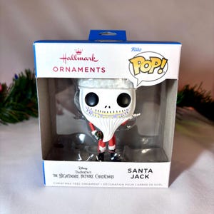 May include: A Santa Jack Funko Pop! Christmas tree ornament in its original box. The ornament features Jack Skellington in a Santa Claus outfit. The box has the Hallmark and Funko Pop! logos, and the text "The Nightmare Before Christmas".