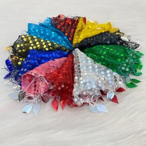 May include: A collection of colorful, sequined fabric triangles arranged in a circular pattern. Each triangle is a different color, including red, blue, and green, and is adorned with silver leaf-shaped embellishments.