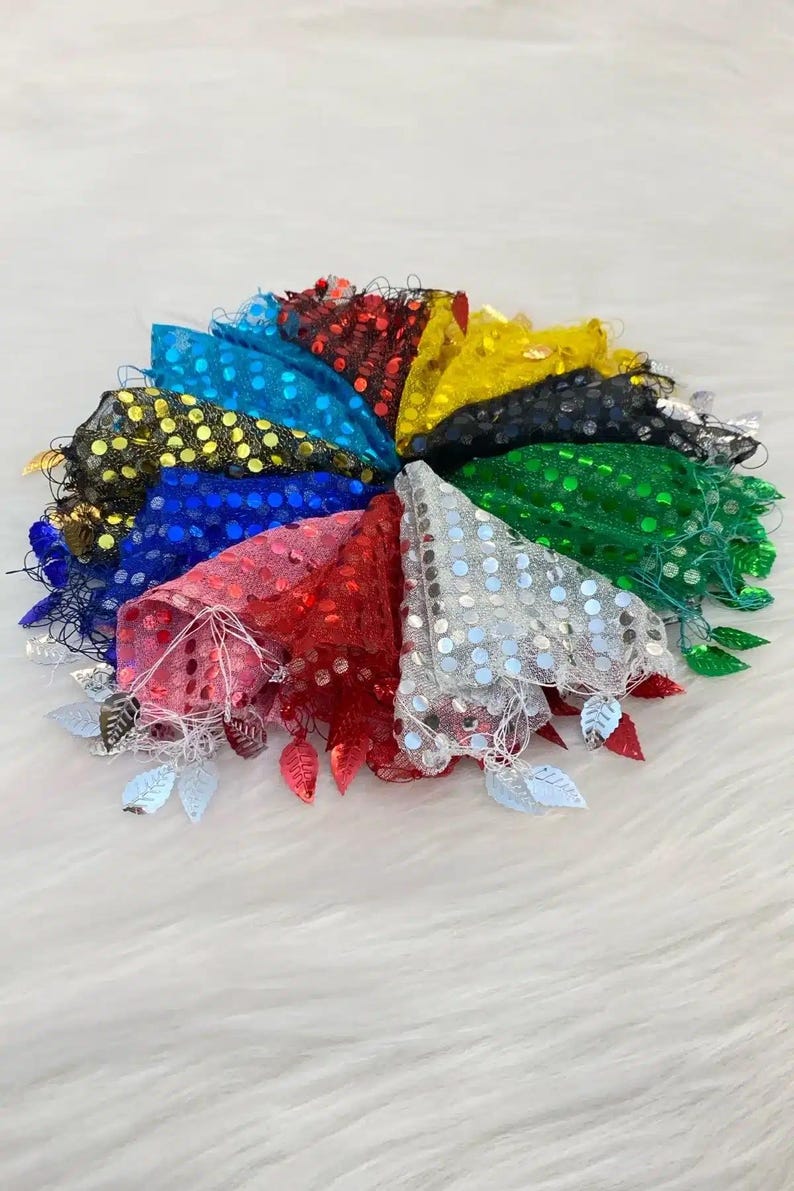 May include: A collection of colorful, sequined fabric triangles arranged in a circular pattern. Each triangle is a different color, including red, blue, green, and yellow, and is adorned with silver leaf-shaped embellishments.