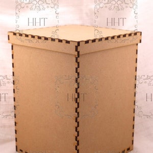 Puede incluir: Una caja cuadrada de madera marrón claro con tapa. La caja tiene un diseño dentado a lo largo de los bordes y las esquinas. Las letras "HHT" son visibles en los lados de la caja.