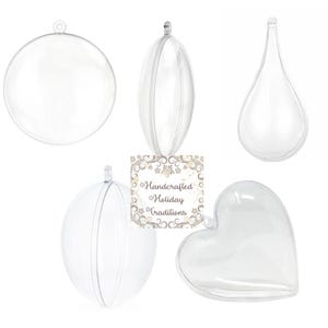 May include: Clear, empty, plastic ornaments in various shapes: a sphere, an oval, a teardrop, a sphere with a seam, and a heart. Each ornament has a small loop for hanging. The image includes a sign that reads "Handcrafted Holiday Traditions."