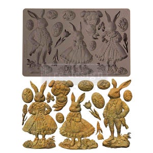May include: A grey silicone mould featuring Easter-themed designs. The mould includes three rabbit figures in Victorian clothing, along with Easter eggs, a sheep, and tulips. The cast pieces are shown in a golden brown colour.