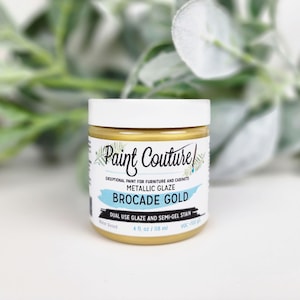 Pu&ograve; includere: Un barattolo di vernice smaltata metallizzata Paint Couture Brocade Gold. L'etichetta recita "Vernice eccezionale per mobili e armadi". Il barattolo contiene 118 ml di vernice a base d'acqua. Il barattolo ha un coperchio bianco e vernice dorata.