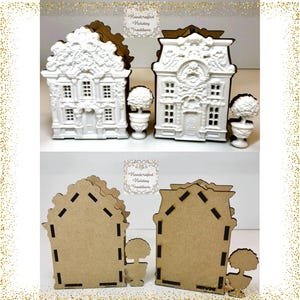 May include: Two white, ornate, three-dimensional house structures with intricate architectural detailing, each accompanied by a small white topiary in a planter. The reverse sides show flat, brown, laser-cut wooden panels with black slot connectors.