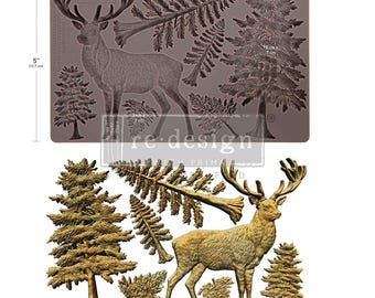 May include: A rectangular silicone mold measuring 8 inches by 5 inches, featuring embossed designs of a stag, pine trees, and fern fronds. Below the mold, the corresponding gold-colored cast shapes are displayed, showing the detailed textures.