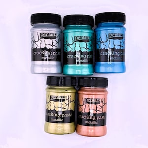 May include: Six small jars of metallic cracking paste in silver, teal, blue, gold, and copper. The jars are labeled "pentart cracking paste metallic".