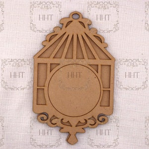 Op de afbeelding: Een houten vogelkooi ornament met een ronde uitsparing in het midden. Het ornament is bruin en heeft een decoratief ontwerp.