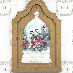 May include: A wooden frame with a cutout in the shape of a bell. Inside the bell is a winter scene with three birds and a poinsettia.