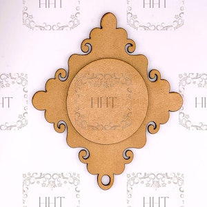 Op de afbeelding: Een decoratief houten frame met een ronde uitsparing in het midden. Het frame heeft een verweerde bruine afwerking en ingewikkelde kruldetails. De uitsparing is ook versierd met kruldetails.
