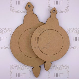 Op de afbeelding: Twee onafgewerkte houten ornamenten in de vorm van kerstballen met een afgeronde bovenkant en een puntige onderkant. De ornamenten zijn leeg en klaar om te worden geschilderd of versierd.