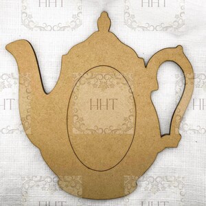 Può includere: Ritaglio di legno a forma di teiera marrone chiaro, con un centro ovale. Il ritaglio presenta un manico, un beccuccio e una parte superiore decorativa. Il centro ovale ha le lettere "HHT". Probabilmente per l'artigianato o l'arredamento della casa.