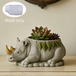 May include: A gray rhinoceros-shaped planter with gold-colored horns and green leaf-like accents along the top edge. A succulent plant is potted inside the hollow back. A translucent silicone mold is shown in the upper left with the text Mold only.