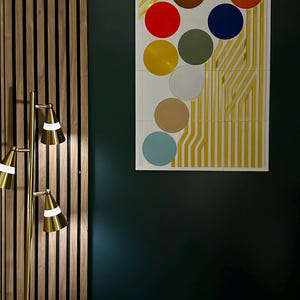May include: A white framed artwork with a geometric design featuring a series of colorful circles on a gold background. The circles are in various colors, including red, orange, yellow, green, blue, brown, and beige.