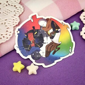 May include: A sticker depicting two cartoon characters, one in blue and black, the other in brown and white, against a rainbow backdrop. The word "ERROR" is visible. Star-shaped decorations surround the sticker.