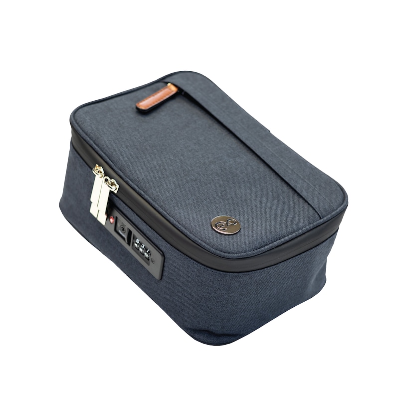 Może przedstawiać: Niebieska torba podr&oacute;żna z zamkiem szyfrowym i brązowym sk&oacute;rzanym suwakiem. Torba ma czarną lam&oacute;wkę i małe srebrne logo.