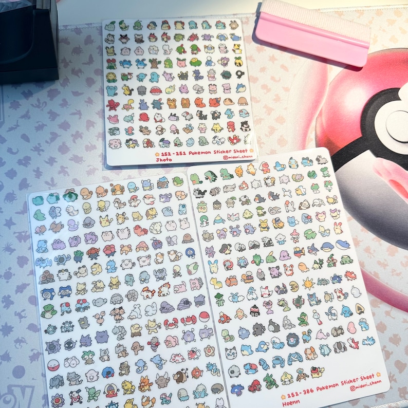 Może przedstawiać: Dwa arkusze papieru z naklejkami Pokemon z 100 naklejkami. Naklejki są małe i przedstawiają r&oacute;żne postacie Pokemon&oacute;w. Naklejki są ułożone w rzędach i kolumnach na arkuszach. Arkusze są oznaczone numerami 152-265 i 161-266 oraz słowami "Pokemon Sticker Sheet" i "Jhoto" i "Hoenn".