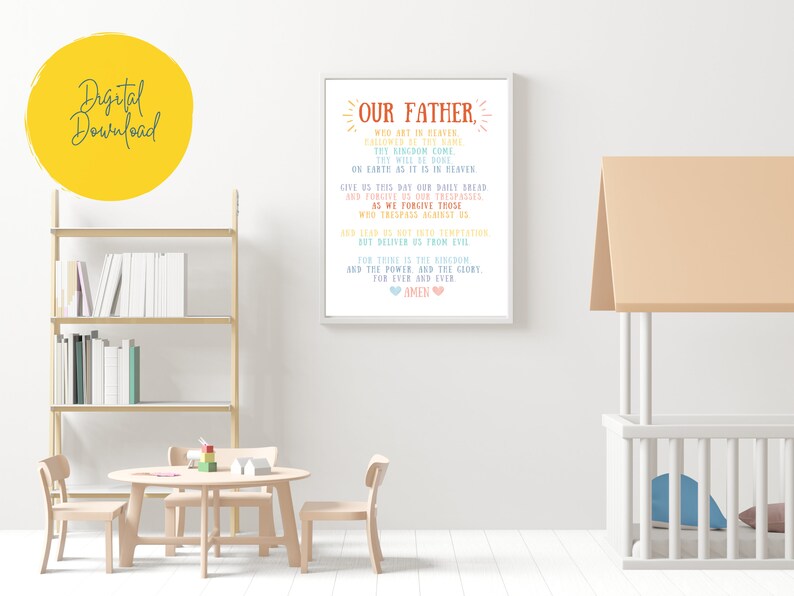 May include: A printable wall art design featuring the Lord's Prayer, "Our Father", in a colorful, handwritten font. The text is framed in a white frame and set against a white wall.