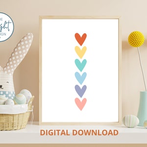 May include: Printable digital download of a rainbow heart design. The hearts are arranged vertically in a line, with the top heart being red, followed by yellow, green, blue, purple, and pink.