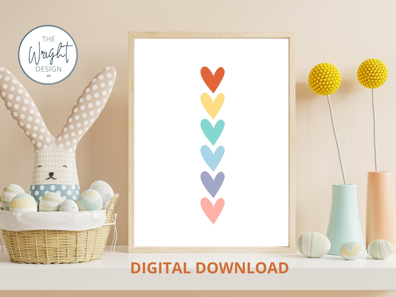 May include: Printable digital download of a rainbow heart design. The hearts are arranged vertically in a line, with the top heart being red, followed by yellow, green, blue, purple, and pink.