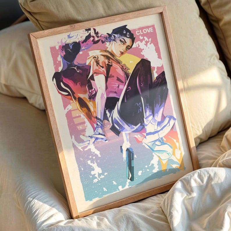 May include: A framed art print featuring a stylized illustration of a person in a dynamic pose, holding a gun. The artwork uses a vibrant color palette of pinks, purples, and blues, with the word "CLOVE" at the top. The frame is made of light-colored wood.