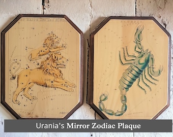 May include: Two wooden plaques with illustrations of the constellations Leo Major and Scorpio. The plaques are part of a set called "Urania's Mirror Zodiac Plaque".