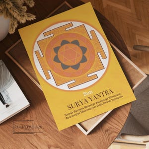 以下が含まれることがあります： オレンジとグレーの色合いの幾何学的なマンダラ模様が描かれた黄色のポスター。ポスターには「Sun SURYA YANTRA」というテキストと、サンスクリットのマントラ「Namah Suryaya Shantaya Sarvaroga Nivaarine, Ayurarogya Maisvairyam Dehi Devah Jagatpate」が書かれています。