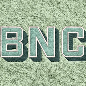 以下が含まれることがあります： ブロックフォントでBNCの文字が刺繍されたライトグリーンのタオル地。文字はライトグリーンで、白い輪郭とダークグリーンのドロップシャドウが施されており、テクスチャーのある生地の上に立体的な効果を生み出しています。