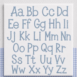 May include: A white square fabric panel featuring the complete English alphabet in both uppercase and lowercase letters. The letters are embroidered in a light blue thread with a textured, rounded font style, arranged in seven neat rows.