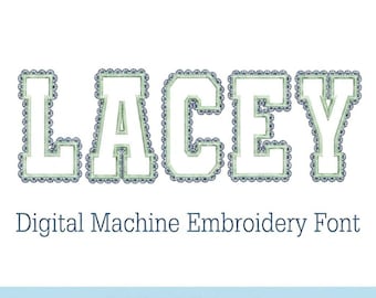 May include: The word "LACEY" in a white, block-style font with a lace edge design in green and blue. Below, the text reads "Digital Machine Embroidery Font" and "LACE EDGE Applique".