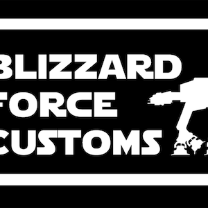 May include: A black and white logo with the text "BLIZZARD FORCE CUSTOMS" inside a rounded rectangle. A white silhouette of a four-legged walker is on the right side of the logo. The logo is designed in a bold, blocky font.