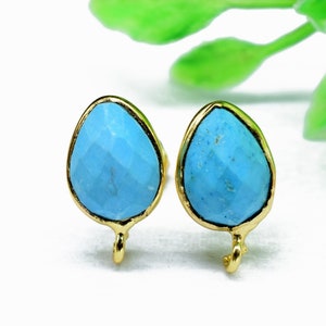 Puede incluir: Un par de pendientes de color dorado con piedras turquesa en forma de lágrima. Los pendientes tienen un diseño sencillo y son perfectos para el uso diario.