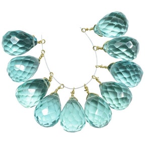 May include: A strand of ten teardrop-shaped faceted beads, each with a gold-toned wire loop. The beads are a light blue-green colour.
