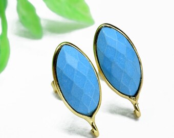 May include: A pair of blue gemstone earrings with gold settings. The gemstones are oval shaped and have a faceted design.
