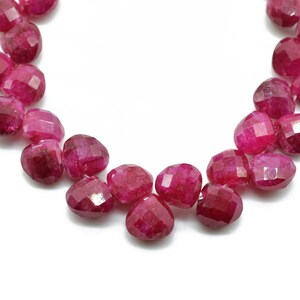 Peut inclure: Un brin de perles de rubis facettées de couleur rouge foncé. Les perles sont de forme ovale et ont une finition lisse et polie.