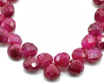 May include: A strand of faceted ruby beads in a deep red colour. The beads are oval shaped and have a smooth, polished finish.