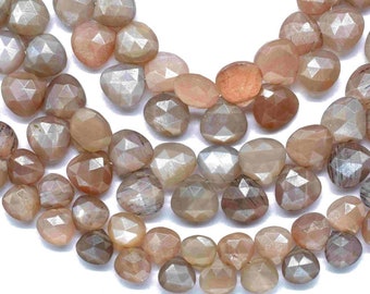 May include: A strand of faceted sunstone beads in shades of peach, brown, and grey. The beads are faceted and have a slightly iridescent sheen.