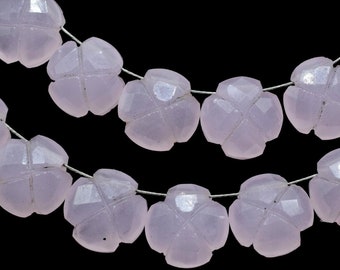 May include: A strand of pale pink gemstone beads, each bead is carved in the shape of a four-leaf clover. The beads are strung on a silver wire.