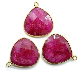 Puede incluir: Tres colgantes de piedra preciosa rosa con engastes de oro. Las piedras preciosas son facetadas y tienen forma de lágrima.