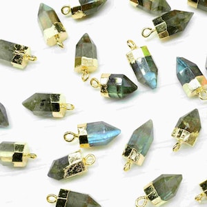 Può includere: Una collezione di 25 ciondoli in cristallo di labradorite placcati in oro. Ogni ciondolo ha la forma di una lacrima appuntita e ha un anello dorato nella parte superiore per attaccarlo a gioielli.